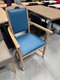 Chaise avec accotoirs ,dossier et assise tapisée en revetement pvc bleu, structure en bois, roulette sur les 2 pieds avant
